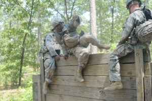 Spc. Derral Whatley, a water treatment specialist with the 431st Quartermaster Detachment and a native of Norfolk, Va., climbs over a wall obstacle during lanes training as part of a combat lifesaver training exercise at Fort Bragg, N.C., June 11. The 431st QM Detachment Soldiers are here providing fresh purified water in support of operations at the 2014 Quartermaster Liquid Logistics Exercise (QLLEX), operationally controlled by the 633rd Quartermaster Battalion. (U.S. Army photo by Pfc. Justin Snyder/Released)